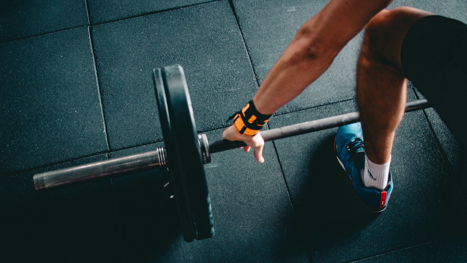 A lifter setting up at a barbell, checking their stance before a rep