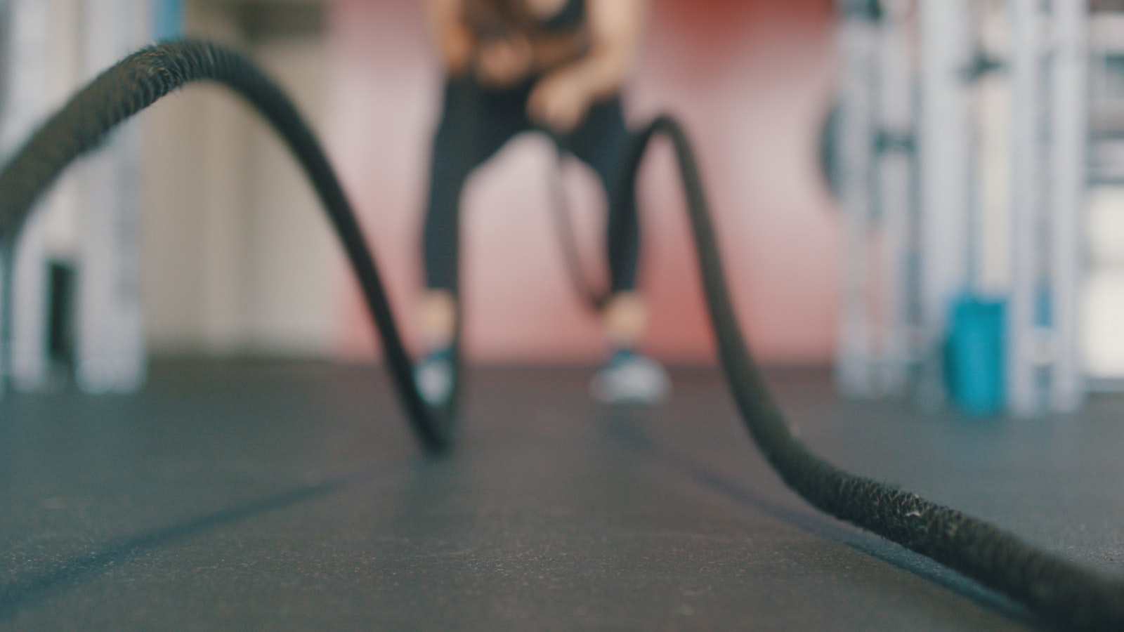 A person catching their breath after an intense interval workout, hands on knees