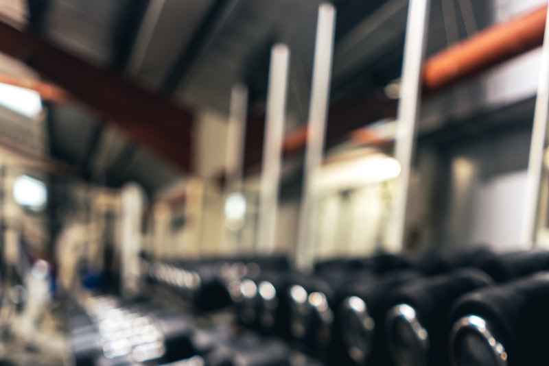 A person warming up carefully before a workout in a bright gym, taking their time
